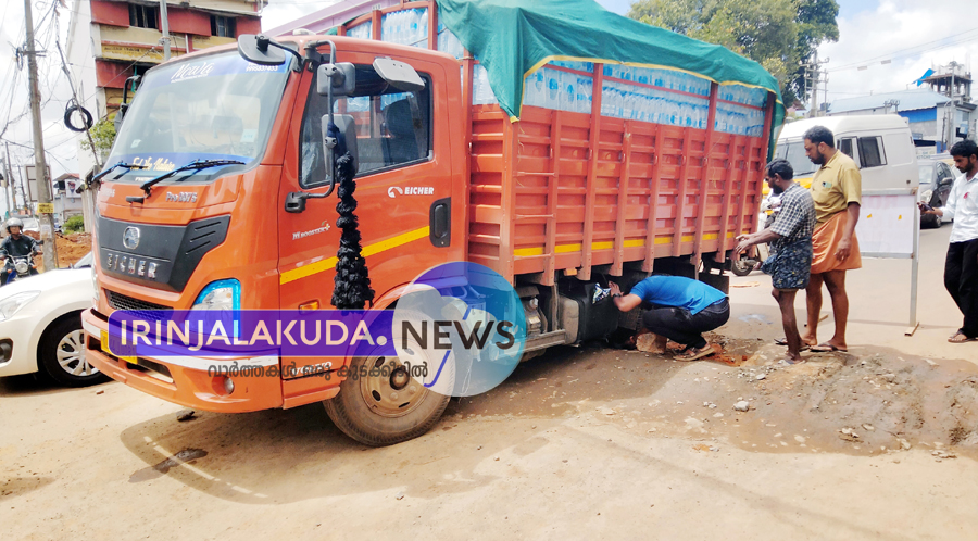 ഇരിങ്ങാലക്കുട ഠാണാ ജംഗ്ഷനില്‍ റോഡിന് കുറുകെ കുടിവെള്ള വിതരണ പൈപ്പ് ഇടുന്നതിനായി എടുത്ത കുഴിയില്‍ മിനിലോറി താഴ്ന്ന നിലയില്‍.