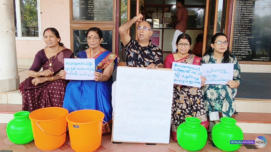 ഇരിങ്ങാലക്കുട നഗരസഭാ കാര്യാലയത്തിന് മുന്നില്‍ കാലിക്കുടങ്ങളും ബക്കറ്റുകളുമായി ബിജെപി കൗണ്‍സിലര്‍മാര്‍ പ്രതിഷേധം നടത്തുന്നു.